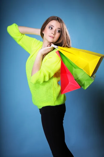 Young woman with paper multi coloured shopping bag — Stock Photo, Image