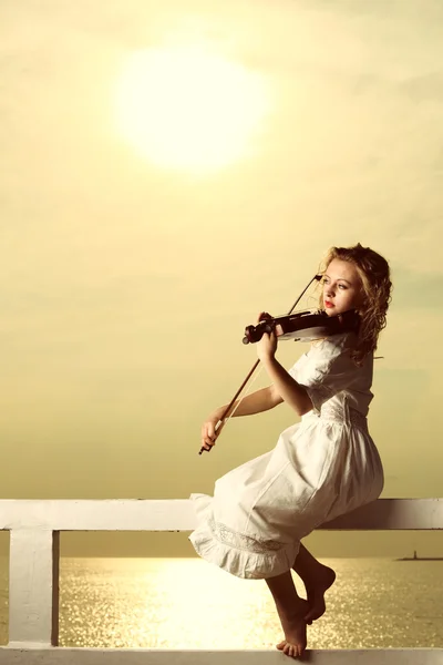 Het blonde meisje met een viool buiten — Stockfoto