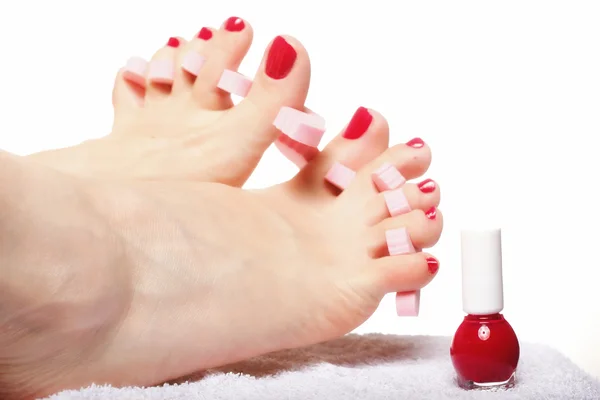 Voetpedicure aanbrengen van rode teennagels op wit — Stockfoto