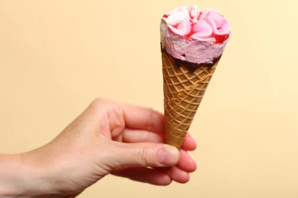 オレンジ色の背景に手でベリーのアイスクリーム — ストック写真