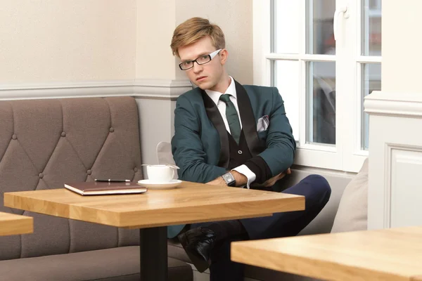 Jeune homme élégant beau dans un café avec du café — Photo