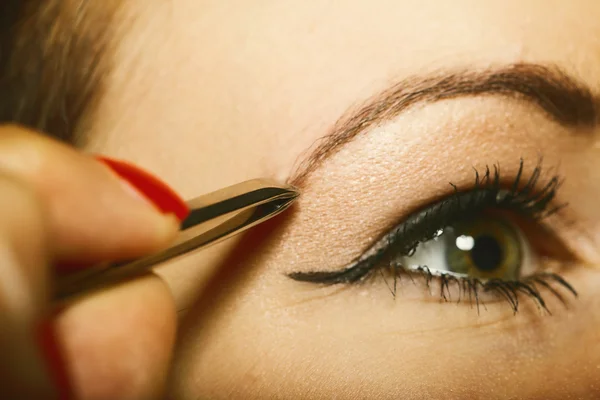 Parte de la cara mujer arrancando las cejas — Foto de Stock