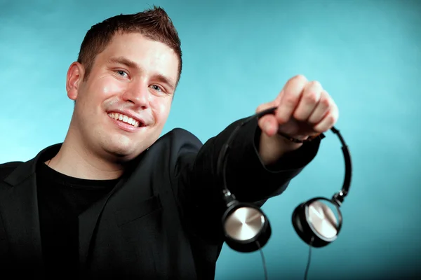 Música e tecnologia, homem sorridente oferecendo fones de ouvido — Fotografia de Stock