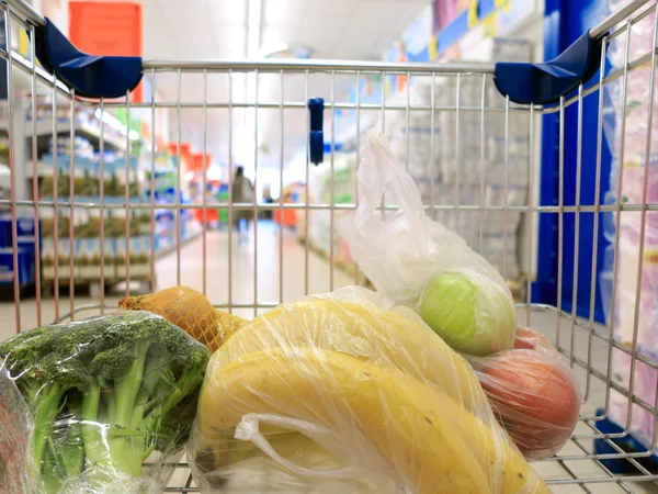 Süpermarkette alışveriş arabası ve market. — Stok fotoğraf