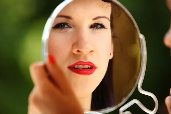 Menina estilo retro aplicando maquiagem olhando espelho interior — Fotografia de Stock