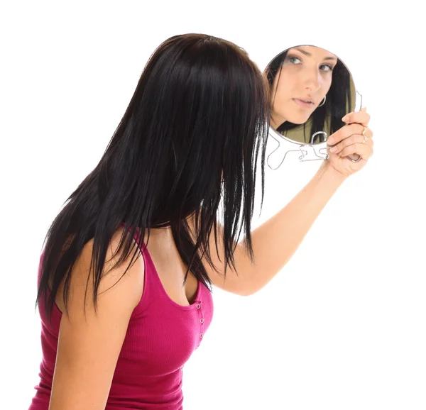 Jovem mulher olhando para o rosto no espelho — Fotografia de Stock