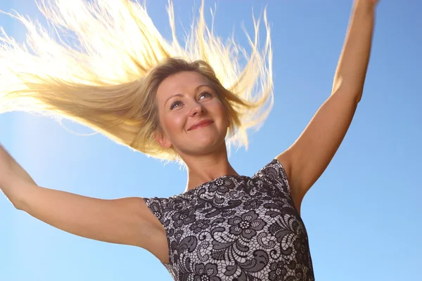 Young woman wind in hair outdoor outstretched arms — Stock Photo, Image