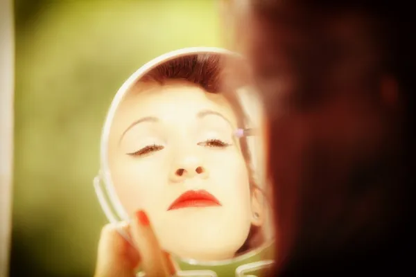 Girl retro style applying make up looking at mirror indoor — Stock Photo, Image