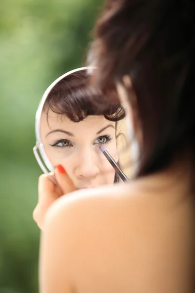 Flicka retrostil tillämpa göra upp titta på spegel inomhus — Stockfoto