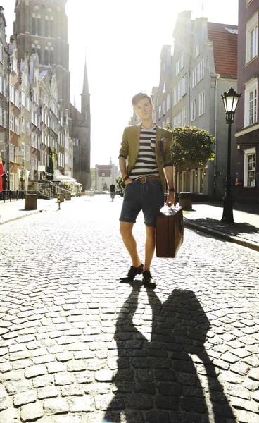 Jeune homme beau avec valise dans la rue — Photo