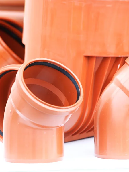 Оранжевые кусочки - дренажные трубы pvc на белом фоне — стоковое фото
