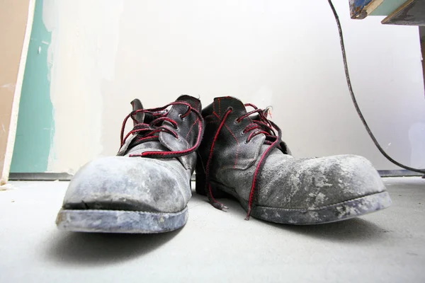 Pair of old dirty work boots in building site Royalty Free Stock Images