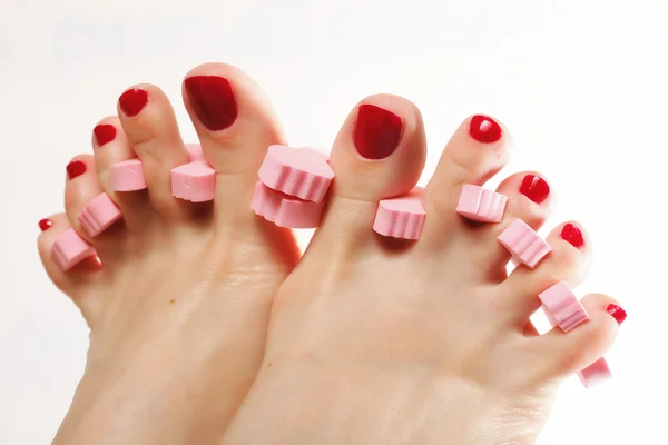 Pedicura del pie aplicando uñas rojas en blanco —  Fotos de Stock