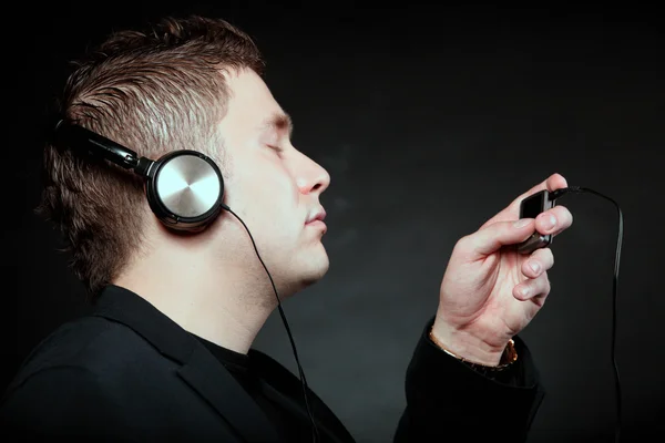 Young man with headphones use mp3 music player — Stock Photo, Image