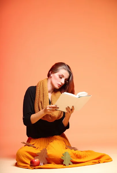 Otoño moda chica con libro naranja pestañas —  Fotos de Stock