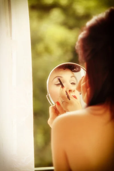 Ragazza stile retrò applicazione make up guardando specchio interno — Foto Stock