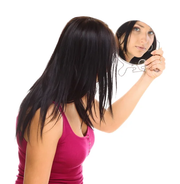 Joven mujer mirando su cara en el espejo — Foto de Stock