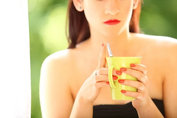 Beautiful Girl Drinking Tea or Coffee Indoor. Green Blurred Background — Stock Photo, Image