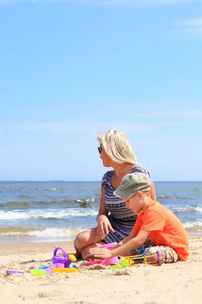 Son and mother playing toys on beach Stock Photo