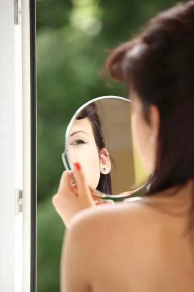 Ragazza stile retrò applicazione make up guardando specchio interno — Foto Stock