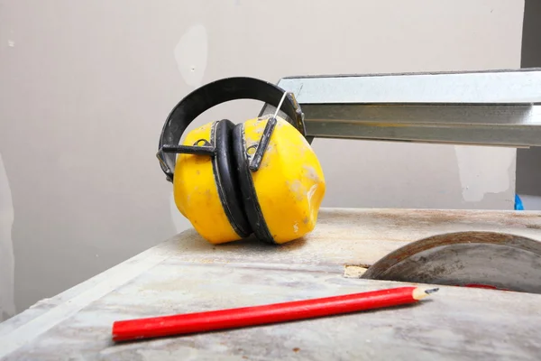 Herramientas de trabajo cortador de sierra para cortar baldosas, auriculares protectores —  Fotos de Stock