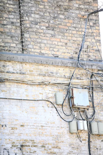 Pole elektryczne kontrolera i plątanina kabli na mur z cegły — Zdjęcie stockowe
