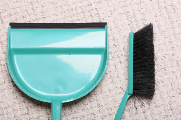 Grüne Kehrbürste und Kehrschaufel auf dem Fußboden - Hausarbeit — Stockfoto