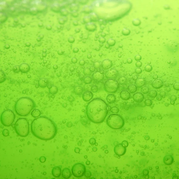 Bolle di sapone verde fondo liquido — Foto Stock