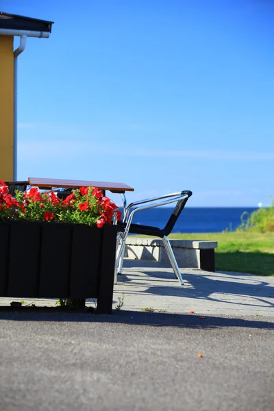 Table de bord de mer et chaises devant la maison — Photo