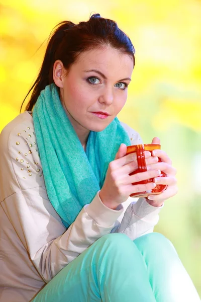 Happy girl relaxing in the autumn park enjoying hot drink — Stock Photo, Image