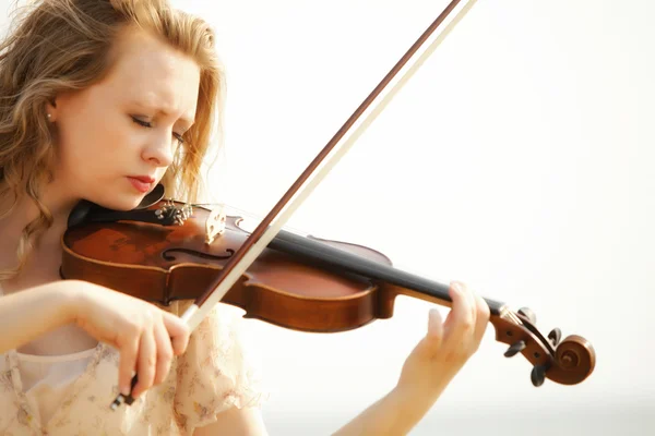 Porträtt blond tjej med en fiol utomhus — Stockfoto