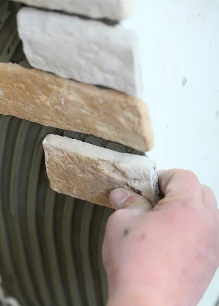 Stavební dělník instalující dlaždice na zeď — Stock fotografie