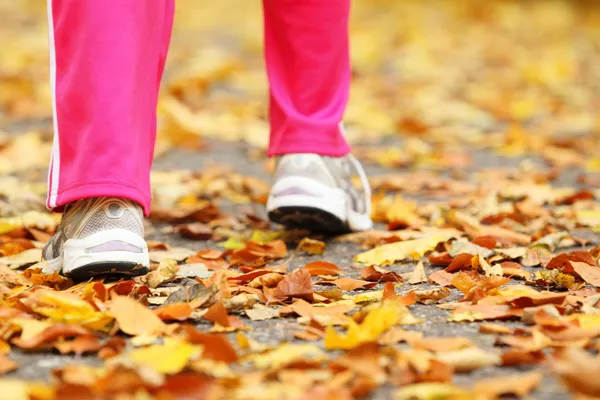 Laufbeine Laufschuhe. Frau joggt im Herbstpark — Stockfoto