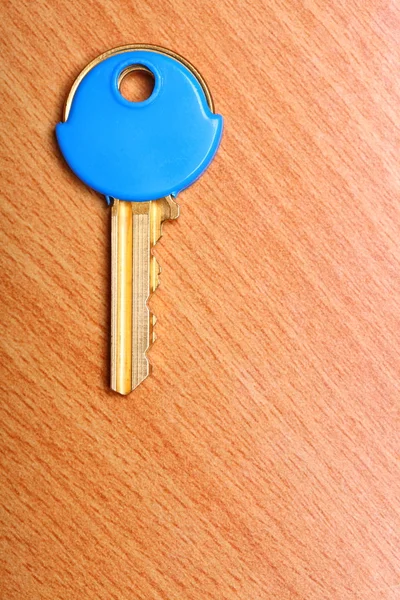 Chave da casa com casacos de plástico azul bonés na mesa — Fotografia de Stock