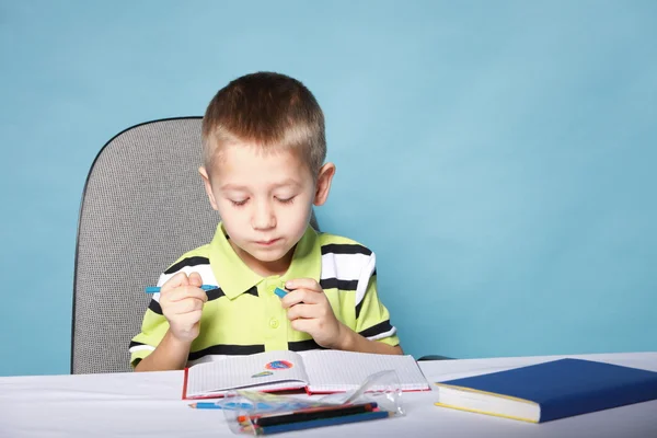 Young cute boy draws with color pencils Royalty Free Stock Photos