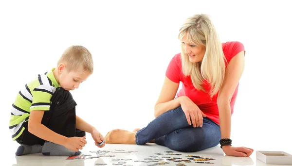 Madre jugando puzzle junto con su hijo — Foto de Stock