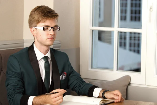 Jonge knappe man van de stijlvolle in café met organizer — Stockfoto