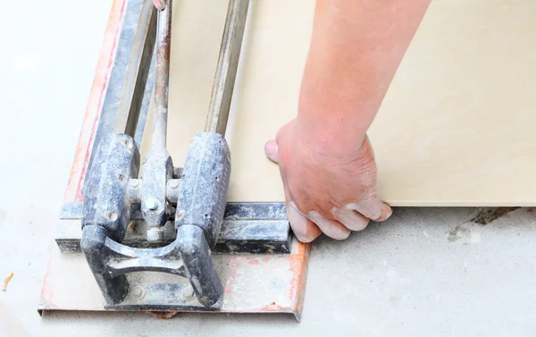 Bauarbeiter schneidet Fliesen zu Hause, Renovierung — Stockfoto