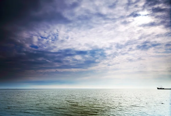Облачно-голубое небо над поверхностью моря — стоковое фото