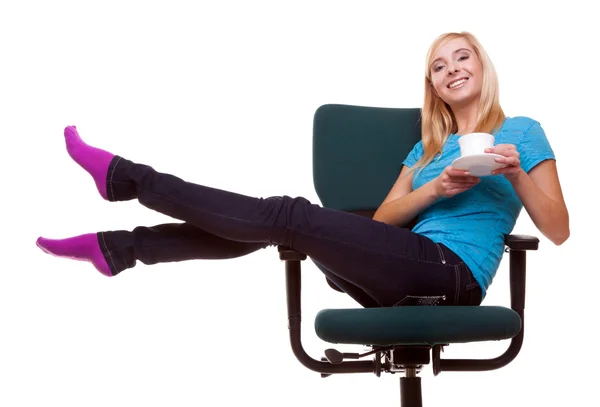 Mooi meisje ontspannen in stoel houdt een kopje thee of koffie. — Stockfoto