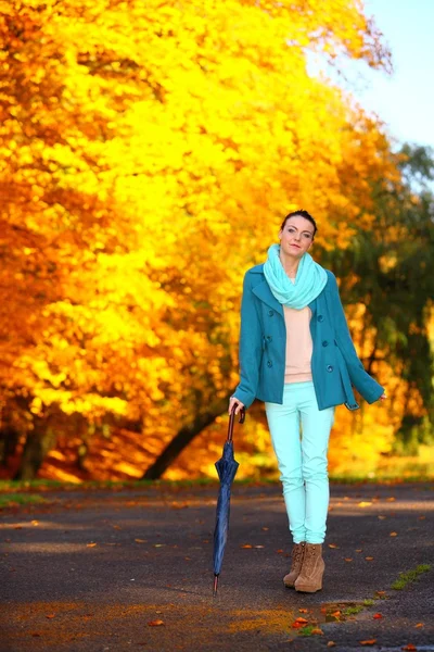 Junges Mädchen spaziert mit Regenschirm durch herbstlichen Park — Stockfoto