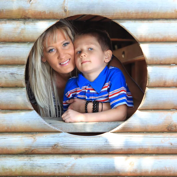 Mãe e filho espreitam através do buraco no playground — Fotografia de Stock