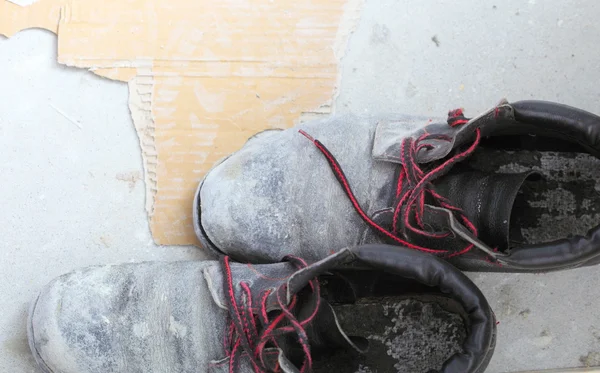 Pair of old dirty work boots in building site Stock Picture