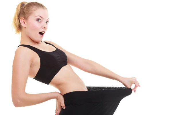 Happy woman showing how much weight she lost, big pants — Stock Photo, Image