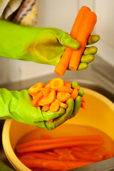 Las manos de mujer cortando zanahorias en la cocina. Nutrición saludable — Foto de Stock