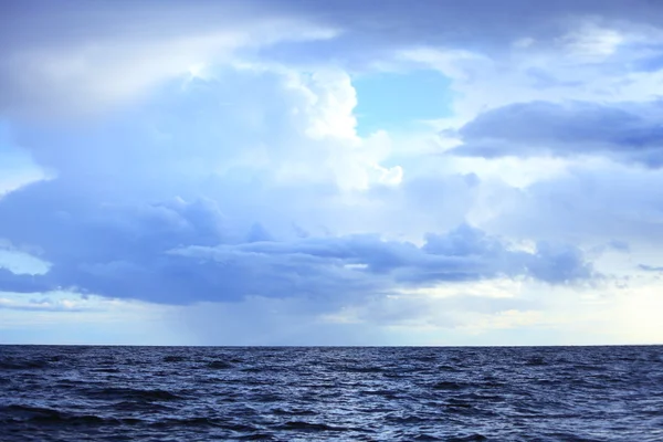 Nublado cielo oscuro sobre una superficie del mar — Foto de Stock