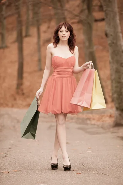 Elegante donna shopper a piedi nel parco dopo lo shopping — Foto Stock