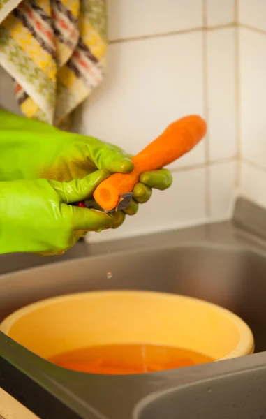 Las manos de mujer cortando zanahorias en la cocina. Nutrición saludable — Foto de Stock