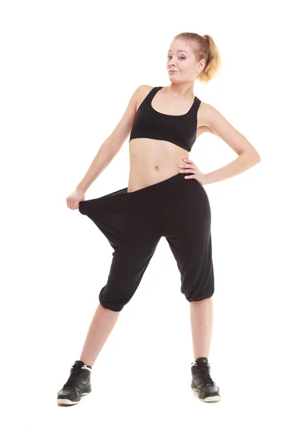 Donna felice che mostra quanto peso ha perso, pantaloni grandi — Foto Stock
