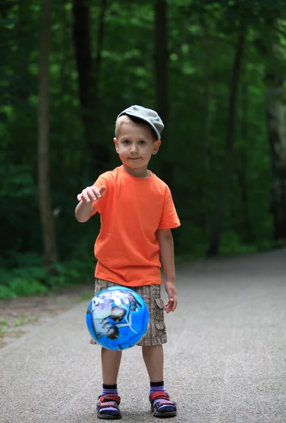 Ragazzo che gioca con la palla in parco all'aperto — Foto Stock